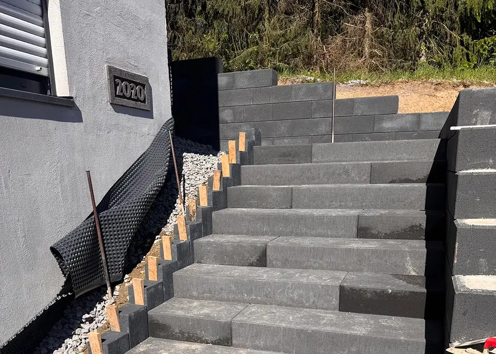 Treppenanlagen Außenanlage mit breiter Treppe aus grauen Betonstufen neben einem Haus